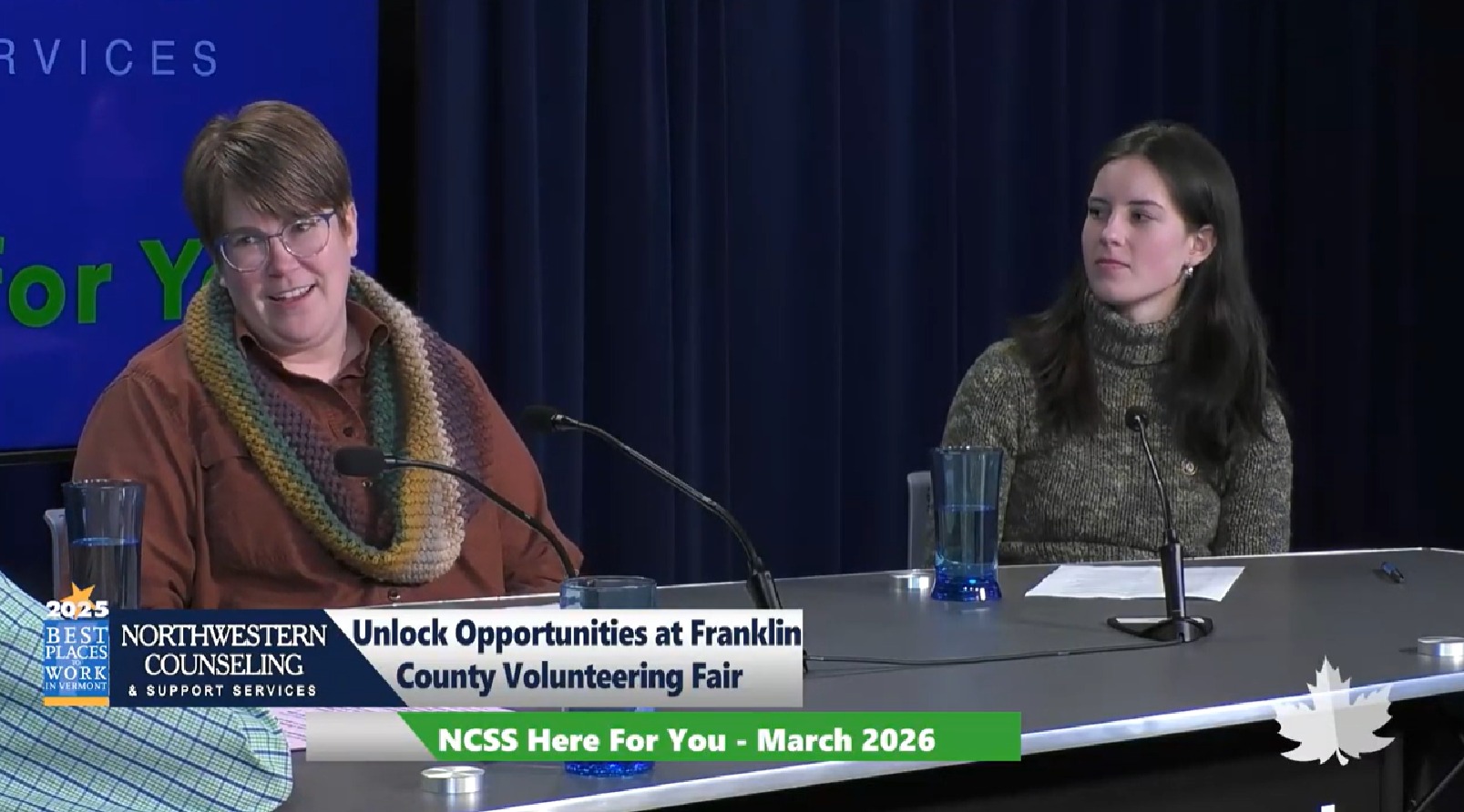 Two women sit at a table with microphones, speaking at an event. A banner reads, Unlock Opportunities at Franklin County Volunteering Fair. A TV graphic shows NCSS Here For You - March 2026.