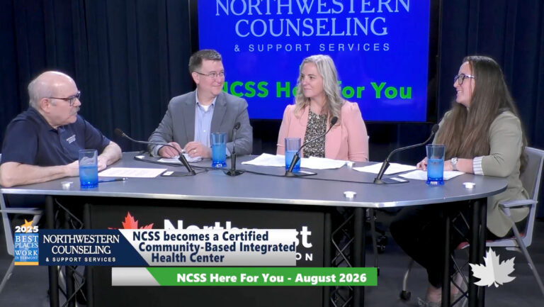Four people sit at a table with microphones, discussing Northwestern Counselings certification as a community-based health center. A tv graphic reads NCSS Here for You - August 2026..